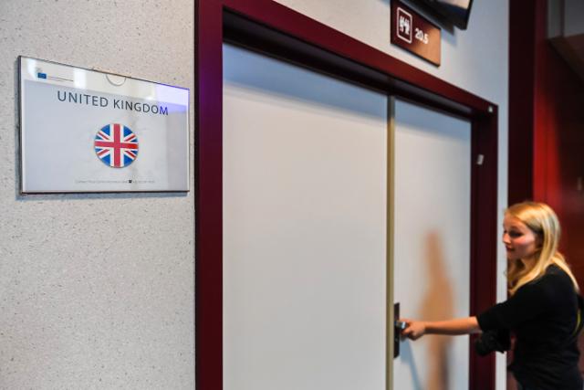 A journalist tries to open the locked door of the British briefing room during an EU summit in Brussels on June 29 (Tanjug/AP)